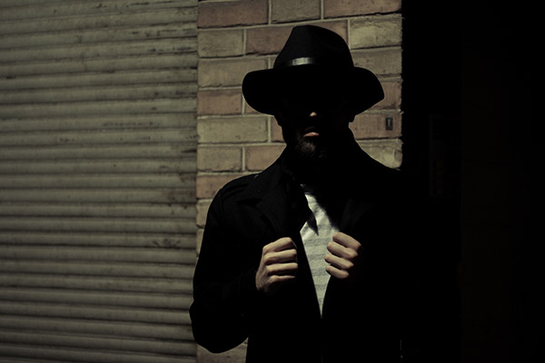 Man in dark in black suit and hat